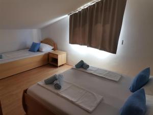 a small room with two beds and a window at Apartments and rooms with parking space Lopar, Rab - 23825 in Rab