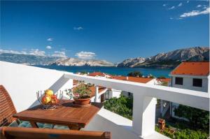 a balcony with a table and a view of the water at Apartments with parking space Baska, Krk - 23742 in Baška