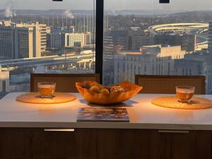 a bowl of fruit on a table with a view of a city at SkyLuxe Heights in Birmingham
