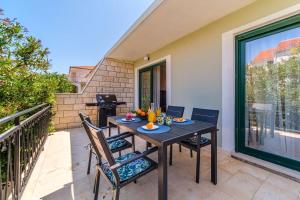 a patio with a table and chairs on a balcony at Family friendly house with a swimming pool Supetar, Brac - 23813 in Supetar