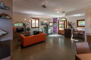 a living room with an orange couch and a kitchen at Oroverde in Bergeggi