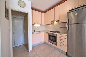 a kitchen with a refrigerator and a clock on the wall at Seaside secluded apartments Drvenik Veliki, Drvenik - 23892 in Veliki Drvenik