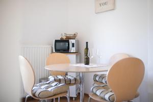 a dining room with a table and chairs with a bottle of wine at Apartments with a parking space Baska, Krk - 23918 in Baška +15 photos