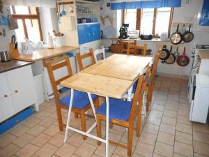 a kitchen with a wooden table and chairs at Chalupa u Evy in Smržovka