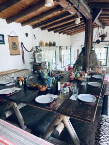 a wooden table with plates and wine glasses on it at Estancia San Pablo in Tupungato