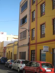 サン・クリストバル・デ・ラ・ラグーナにあるLa Laguna Centroの黄色い建物の前に停車する車両群