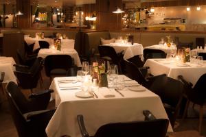 a dining room with white tables and black chairs at The Guesthouse Vienna in Vienna