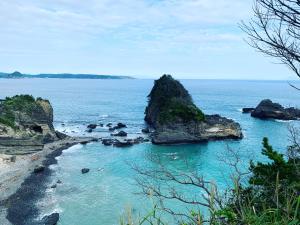 a beach with some rocks in the water at HealingDragon Ryugu cottage in Shimoda +12 photos