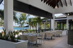 eine Außenterrasse mit Tischen, Stühlen und Meerblick in der Unterkunft Peter Island Resort in Anderson