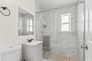 a bathroom with a shower and a toilet and a sink at 3 bedrooms and 2 bathrooms Charming Beachside House with King Bed in Pompano Beach +36 photos