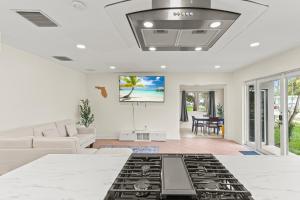 a living room with a couch and a tv at 3 bedrooms and 2 bathrooms Charming Beachside House with King Bed in Pompano Beach