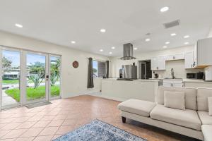 a living room with a couch and a kitchen at 3 bedrooms and 2 bathrooms Charming Beachside House with King Bed in Pompano Beach