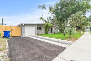 a driveway in front of a house at 3 bedrooms and 2 bathrooms Charming Beachside House with King Bed in Pompano Beach