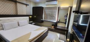 a bedroom with a bed and a flat screen tv at SRI ViJETHA ROYAL in Rājahmundry