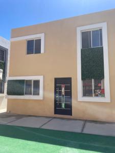 un edificio con una porta nera e due finestre di Departamento Mazatlan a Mazatlán
