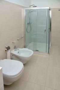 a bathroom with a shower and a toilet and a sink at Spazi Preziosi in Torre San Giovanni Ugento