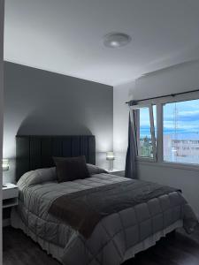 a bedroom with a large bed and a window at Altos Patagonia in Río Gallegos