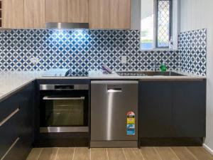 a kitchen with a stainless steel dishwasher and a sink at The Mooloolaba Gallery in Mooloolaba +10 photos