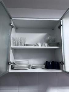 a cabinet filled with plates and bowls and glasses at Altos Patagonia in Río Gallegos