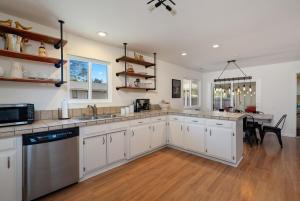a large kitchen with white cabinets and a table at Boots and Barrels Ranch in Paso Robles