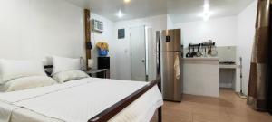 a bedroom with a bed and a kitchen with a refrigerator at John and Novy Camotes Beach Bungalows in San Francisco +18 photos