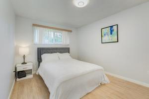 a white bedroom with a white bed and a window at Stunning House In Victoria, BC in Victoria