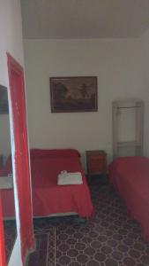 a bedroom with two beds and a red bedspread at Parque Chacabuco in Mar del Plata +2 photos