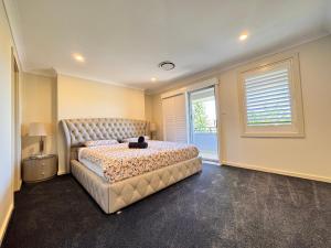 a bedroom with a large bed and a window at Blue Haven Retreat - Jordan Springs in Kingswood