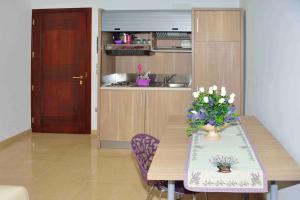 a kitchen with a wooden table with flowers on it at Spazi Preziosi in Torre San Giovanni Ugento +14 photos