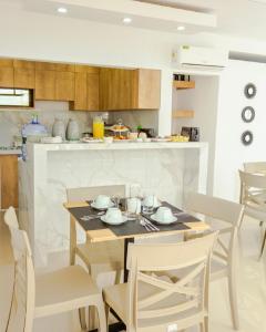 een keuken en eetkamer met een tafel en stoelen bij Hotel Kikos Plaza in Tumbes
