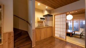 a japanese kitchen with wooden cabinets and a window at 京一軒町家 染 SEN 七条花畑 Shichijo-Hanabatake in Kyoto