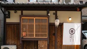 a building with a gate and a sign on it at 京一軒町家 染 SEN 七条花畑 Shichijo-Hanabatake in Kyoto