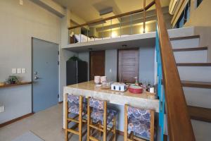 a kitchen with a bar with stools and a loft at Lux Sea Studio 1 in San Juan