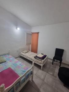 a room with two beds and a chair in it at Casa amplia in Villa Constitución