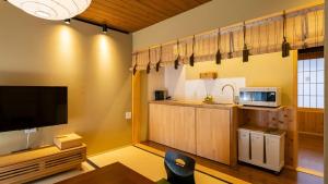 un soggiorno con TV e cucina di 京一軒町家 染 SEN 七条壬生 Shichijo-Mibu a Kyoto