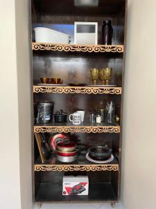 a cupboard filled with lots of pots and pans at Kitnets Prático Aconchego in Petrolina +13 photos