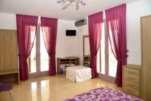 a living room with pink curtains and a room with a bed at Spazi Preziosi in Torre San Giovanni Ugento