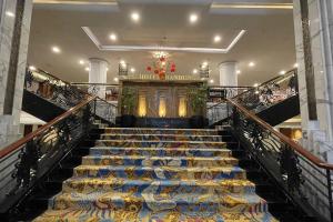 a staircase in a building with blue and gold seats at eL ROYALE by Farizi Rooms in Bandung +72 photos