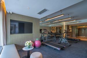 a room with a gym with exercise equipment and a tv at Lijiang Old Town Echarm Plus Hotel in Lijiang