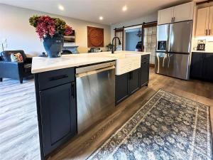a kitchen with a large island with a vase of flowers at Sqc Cedar St Cottage in Sequim +3 photos