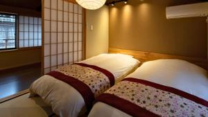 two beds in a room with a room with windows at 京一軒町家 染 SEN 大宮五条 Omiya-Gojo in Kyoto