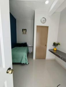 a bedroom with a bed and a clock on the wall at Casa azul in Tecomán +3 photos