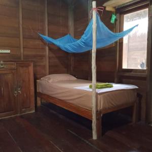 un lit avec un filet bleu dessus dans l'établissement Papajamsurfcamp, à Masokut