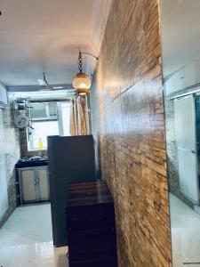 eine Küche mit Ziegelwand in einem Zimmer in der Unterkunft Den near the sea in Mumbai