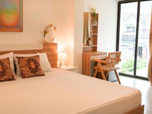een slaapkamer met een bed, een bureau en een stoel bij Place Hotel in Kata Beach +51 foto's