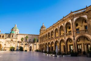 a large building with a courtyard in front of it at Casa vacanza Sofiu' in Mazara del Vallo