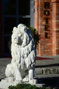 una statua di leone di fronte a un edificio di Royal Hotel Modlin a Nowy Dwór Mazowiecki