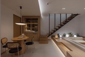 a living room with a staircase and a table and chairs at Vibe Hotel Masan Hapseong in Changwon