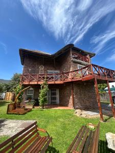 a large brick house with a deck on a yard at Hemel in Hermanus Three bedroom Home in Hermanus