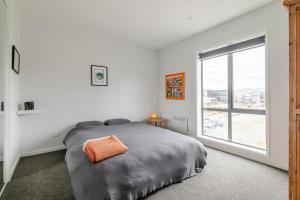 Un dormitorio con una cama y una ventana grande. en 2024 Townhouse, en Christchurch